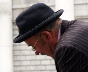 a horse-drawn carriage driver with a sort-of-a-bowler hat