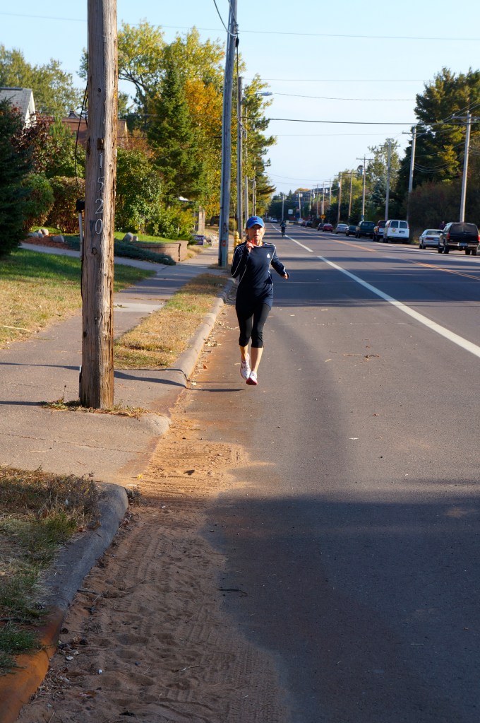 Patricia running on Park Point - with a bit of Fall in her hand