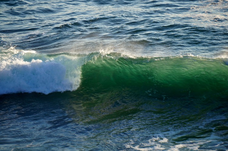 green hue of the the sun in a wave